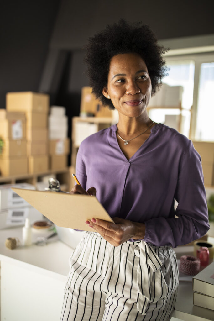 Confident businesswoman holding a clipboard, smiling and contemplating