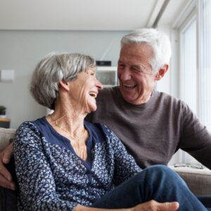 Two older people smiling at one another.